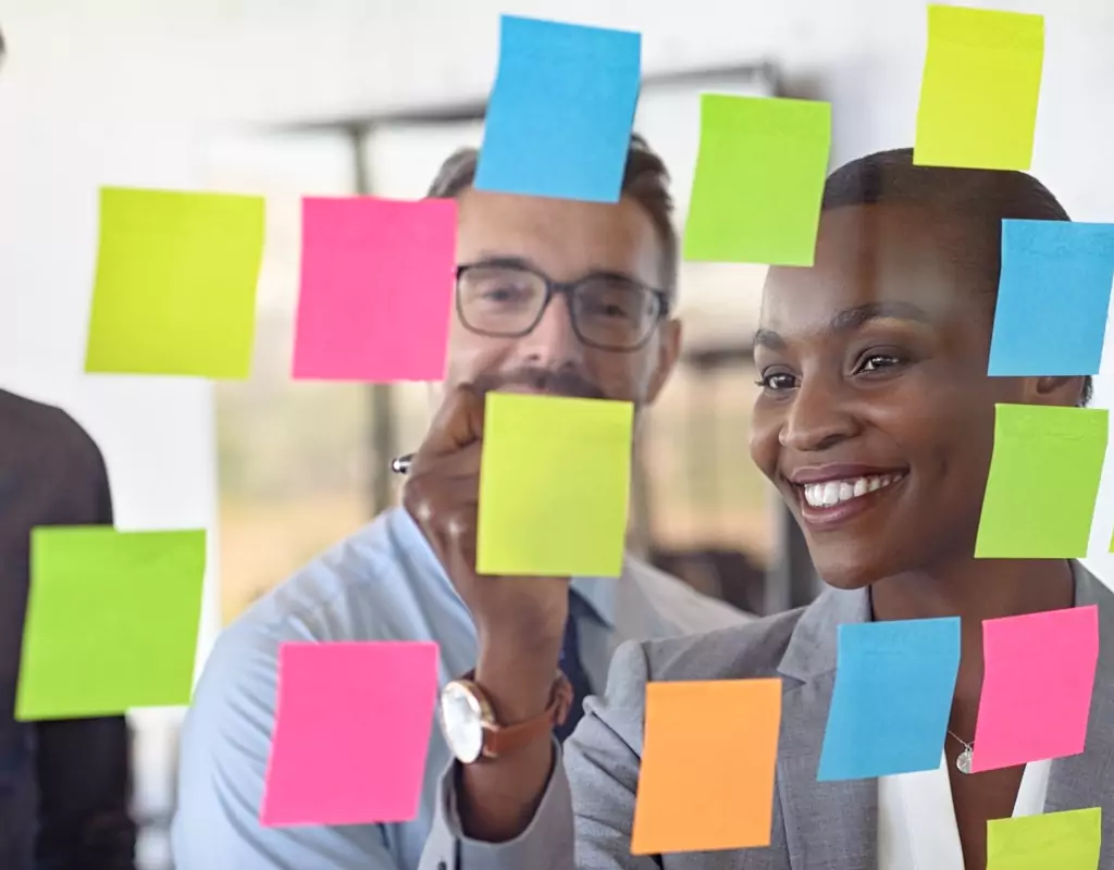 Interactive Agile Training Workshop in action, with professionals engaging in Agile Implementation Strategies using post-it notes.